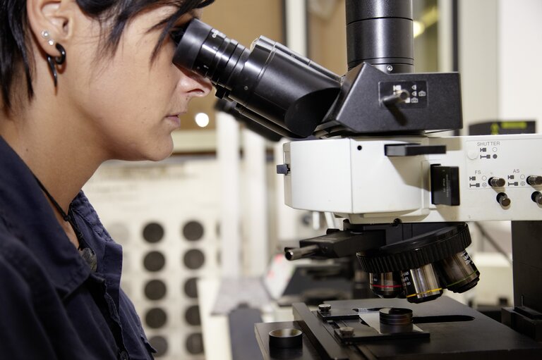 Werkstofftechnik - Metallkunde - Werkstoffpruefung im RÜBIG Werkstofflabor: Mitarbeiterin untersucht Proben am Mikroskop im RCC